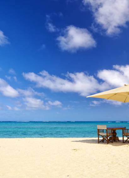 Table, chairs and umbrella on sand beach in Mauritius Island